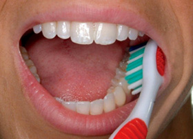 Place the toothbrush against your gumline at a 45-degree angle. Move the brush back and forth gently in short strokes.