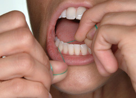 Hold the floss tightly against the tooth. Gently rub the side of the tooth, moving the floss away from the gum with up and down motions.